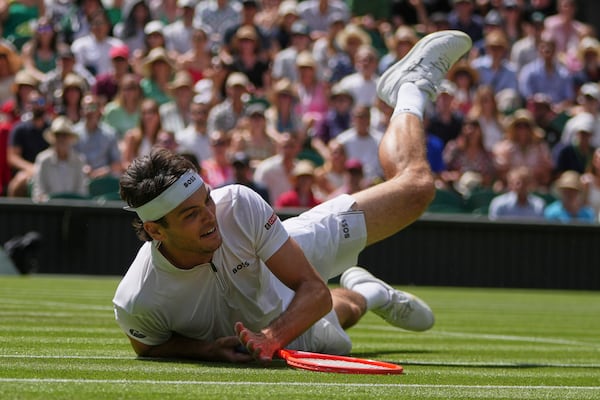 Taylor Fritz of the U.S. falls to the court after diving to return to Alejandro Davidovich Fokina of Spain during a third round singles match at the Wimbledon Tennis Championships in London, Friday, July 4, 2025. (AP Photo/Kin Cheung)