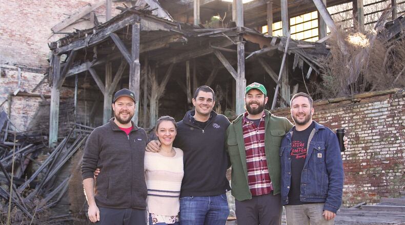 Creature Comforts' five original employees. From left to right: Adam Beauchamp (Co-founder & Brewmaster), Katie Beauchamp (Tasting Room General Manager & Community Outreach), Chris Herron (Co-founder & CEO), Blake Tyers (Wood Cellar & Specialty Brand Manager), and David Stein (Co-founder & Head Brewer). Credit: Creature Comforts.