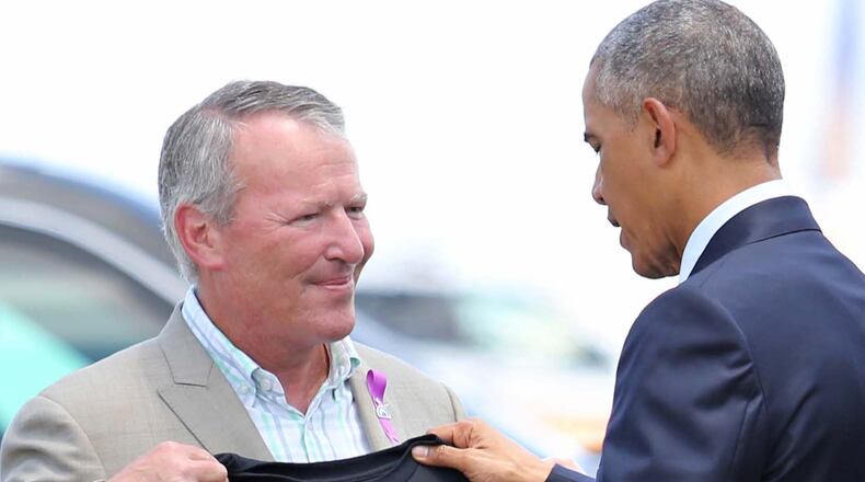President Barack Obama looks at a T-shirt that was presented to him by Orlando, Fla. Mayor Buddy Dyer upon the president's his arrival at Orlando International Airport, Thursday, June 16, 2016, in Orlando, Fla. Obama is in Orlando today to pay respects to the victims of the Pulse nightclub shooting and meet with families of victims of the attack. (Joe Burbank/Orlando Sentinel via AP)