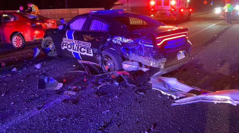A Sandy Springs police officer was injured early Thursday morning when her patrol car was hit while she was parked on the shoulder of I-285. The other driver was cited for texting while driving.