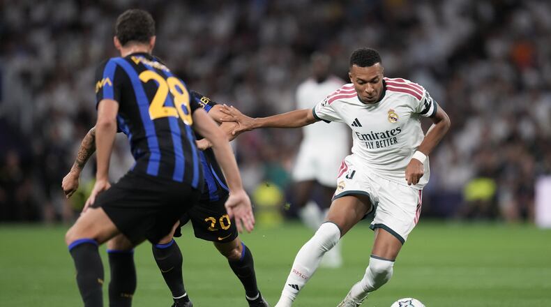 Real Madrid's Kylian Mbappe fights for the ball against Inter Milan's Hakan Calhanoglu before scoring the opening goal, during a Champions League soccer match between Real Madrid and Inter Milan in Madrid, Spain, Tuesday, Sept. 8, 2026. (AP Photo/Bernat Armangue)
