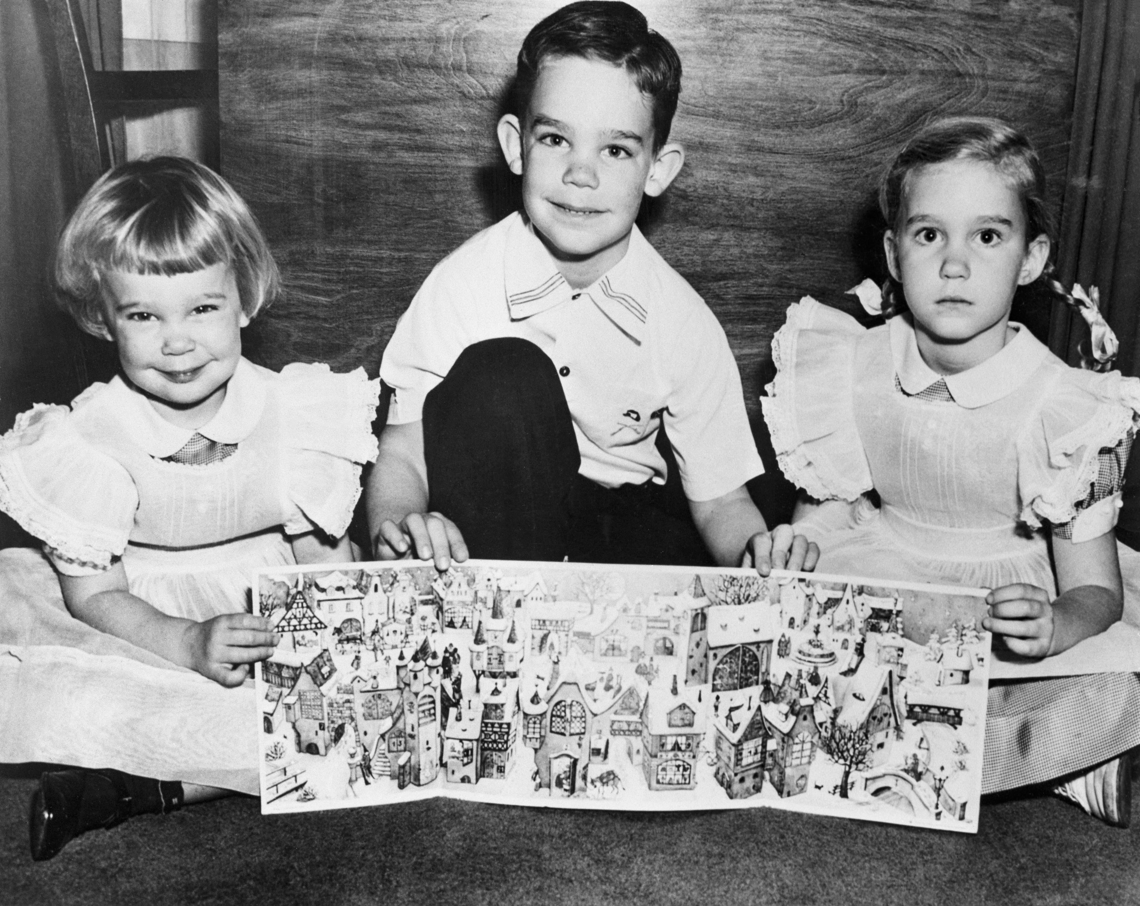 President Dwight D. Eisenhower's three grandchildren join in an appeal for sales of "Little Christmas Town" Advent calendars by the national Epilepsy League. Holding one of the calendars are (from left) Susan, 3; David, 6; and Barbara, 5. All our children of the president's son, Maj. John Eisenhower. (Bettmann Archive/Getty Images)