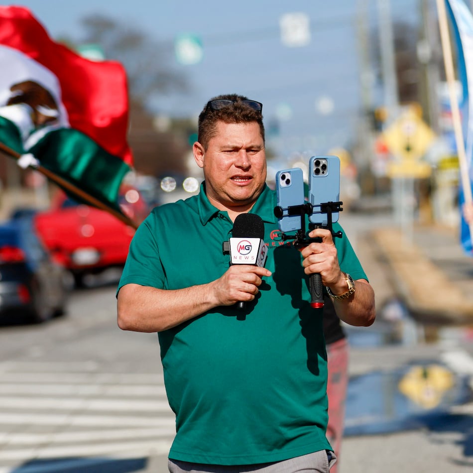 Mario Guevara, a metro Atlanta-based Spanish-language reporter, covers a protest against immigration enforcement on Feb. 1, 2025, on Buford Highway. (Miguel Martinez/AJC)