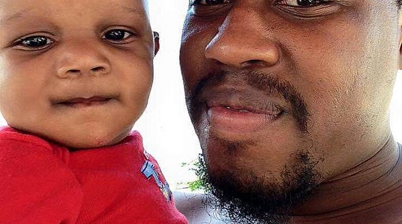 JD Ferguson, shown holding his son, Jordan, was shot to death Sunday night while working as a security guard. (Family photo)