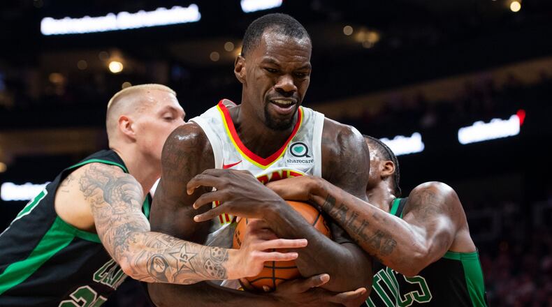 Hawks center Dewayne Dedmon tries to keep the ball from Boston Celtics guard Marcus Smart, right, and forward Daniel Theis, left. (AP Photo/John Amis)