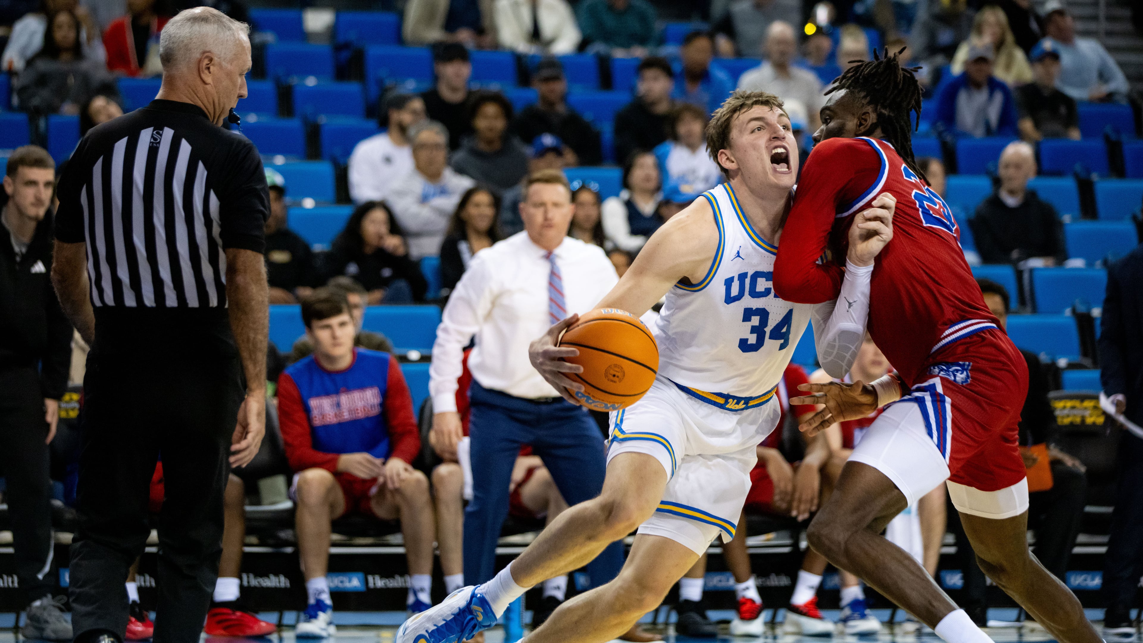 UCLA forward Tyler Bilodeau (34) is defended by West Georgia forward Kenneth Chime, right, during the first half of an NCAA college basketball game Monday, Nov. 10, 2025, in Los Angeles. (AP Photo/Ethan Swope)