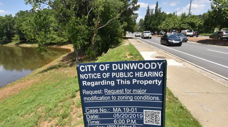 A “Notice of Public Hearing” sign is posted near Ashford Dunwoody Road in Dunwoody  where developers hope to redevelop an old restaurant hub in the Perimeter Center area, adding a gas station, grocery store, a bank and a new road. HYOSUB SHIN / HSHIN@AJC.COM
