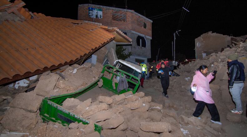 Residents walk amid the debris of homes that collapsed after an earthquake struck Pumpuya, Peru, Sunday, July 19, 2026. ( AP Photo/Javier Ninanya)