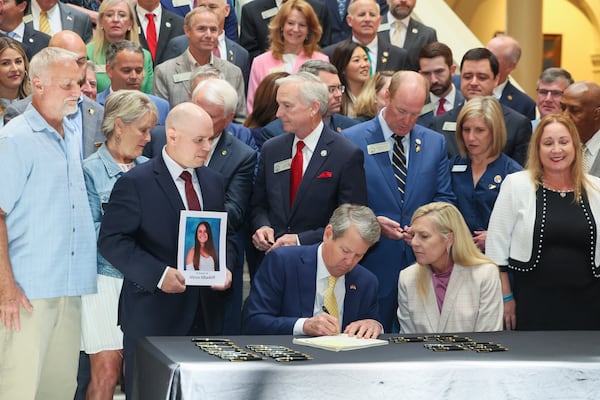 Gov. Brian Kemp, next to first lady Marty Kemp signs the student safety bill, House Bill 268, at the north wing steps of the Georgia State Capitol, Monday, April 28, 2025, in Atlanta. (Jason Getz/Atlanta Journal-Constitution via AP, Pool)