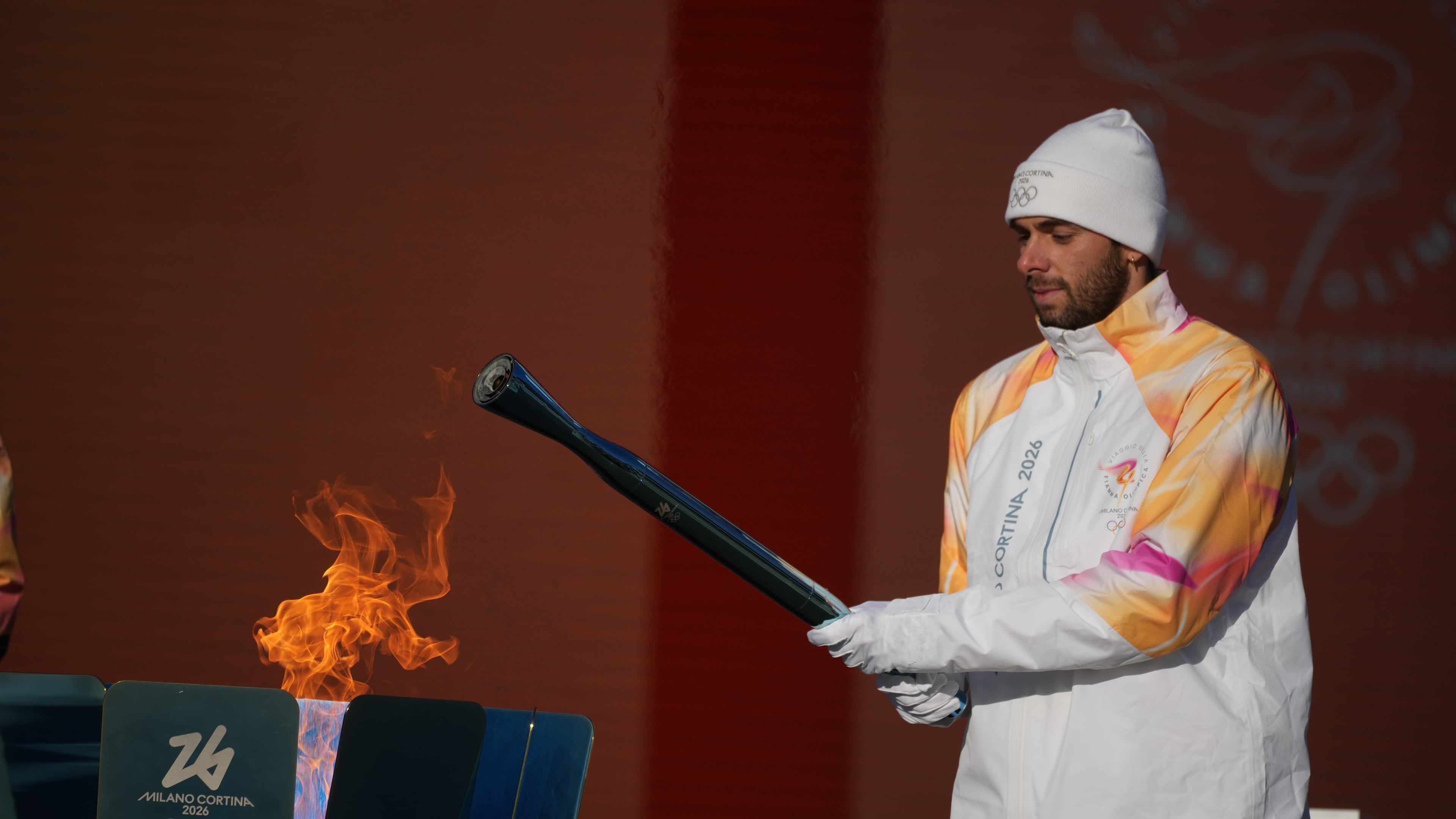 Italian swimmer Gregorio Paltrinieri lights the 2026 Milan Cortina Winter Olympics torch in Rome as it begins its journey through Italy, Saturday, Dec. 6, 2025, a journey that will conclude in Milan in February 2026. (AP Photo/Andrew Medichini)