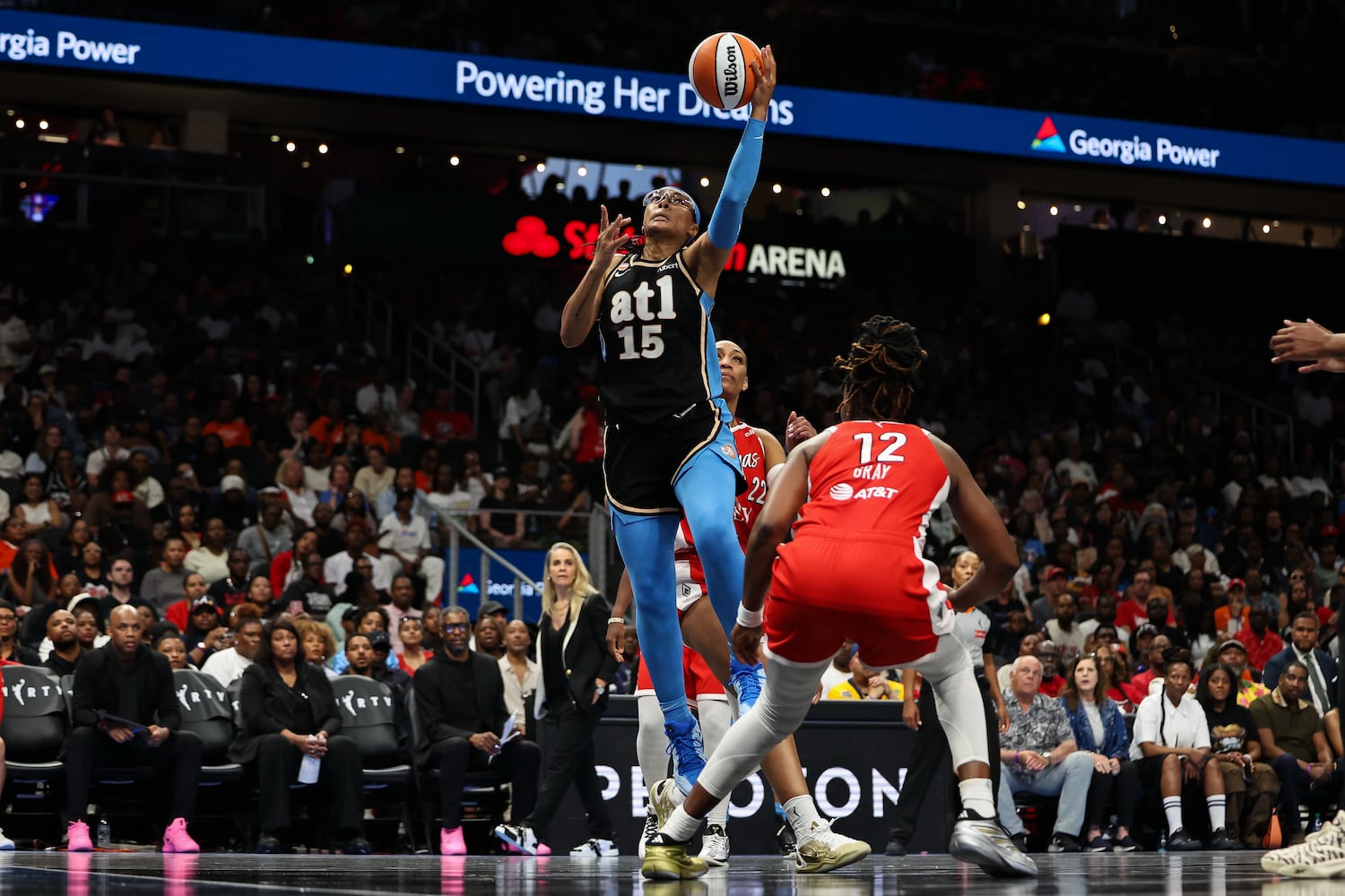 Dream guard Allisha Gray (center) shoots over Aces guard Chelsea Gray during the first half Sunday, May 17, 2026, at State Farm Arena in Atlanta. (Colin Hubbard for the AJC) 