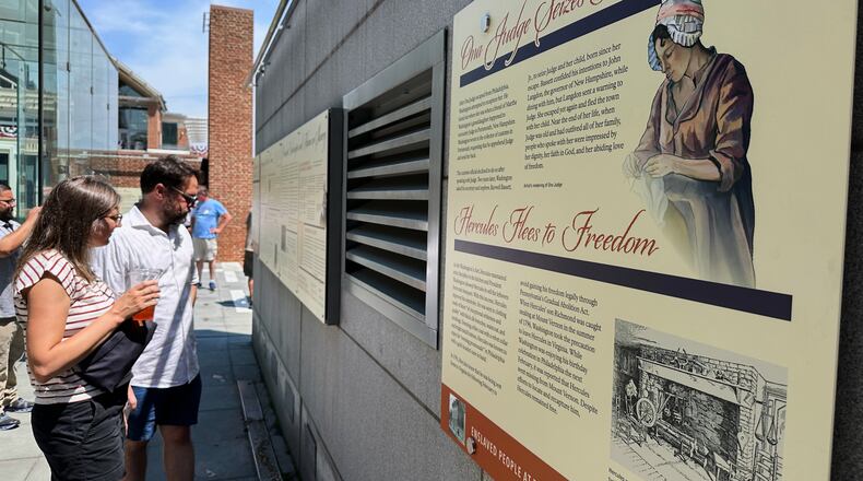 Visitors view the reinstalled educational panels about slavery at the site of President George Washington's home in Philadelphia, Wednesday, July 15, 2026. (AP Photo/Tassanee Vejpongsa)