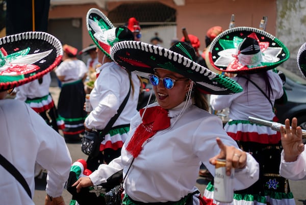 FILE - Women dance during a re-enactment of The Battle of Puebla as part of Cinco de Mayo celebrations in the Peñon de los Baños neighborhood of Mexico City, May 5, 2022. (AP Photo/Eduardo Verdugo, File)