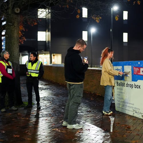 FILE - A voter poses for a photo as they place their ballot in a drop box on Election Day, Nov. 5, 2024, in Seattle. (AP Photo/Lindsey Wasson, File)