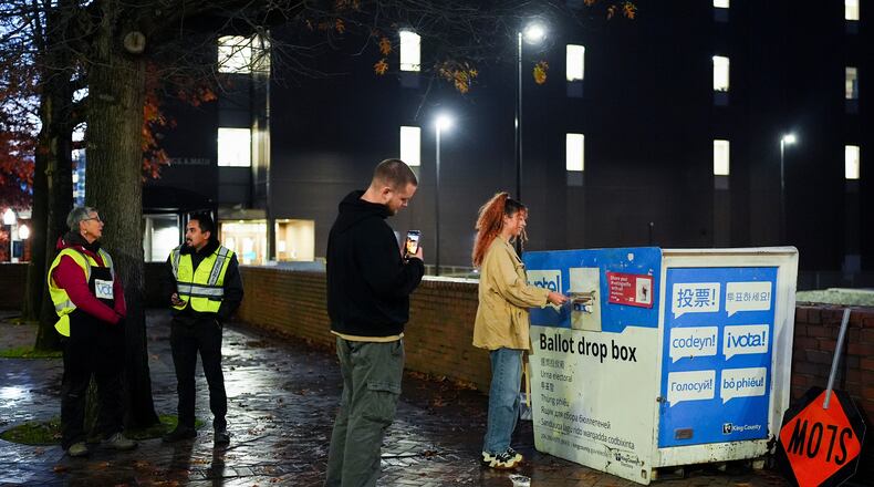 FILE - A voter poses for a photo as they place their ballot in a drop box on Election Day, Nov. 5, 2024, in Seattle. (AP Photo/Lindsey Wasson, File)