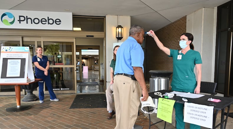 A nurse checks a temperature of an employee before he enters the Phoebe Putney Memorial Hospital in Albany on Tuesday, March 24, 2020. (Hyosub Shin / Hyosub.Shin@ajc.com)