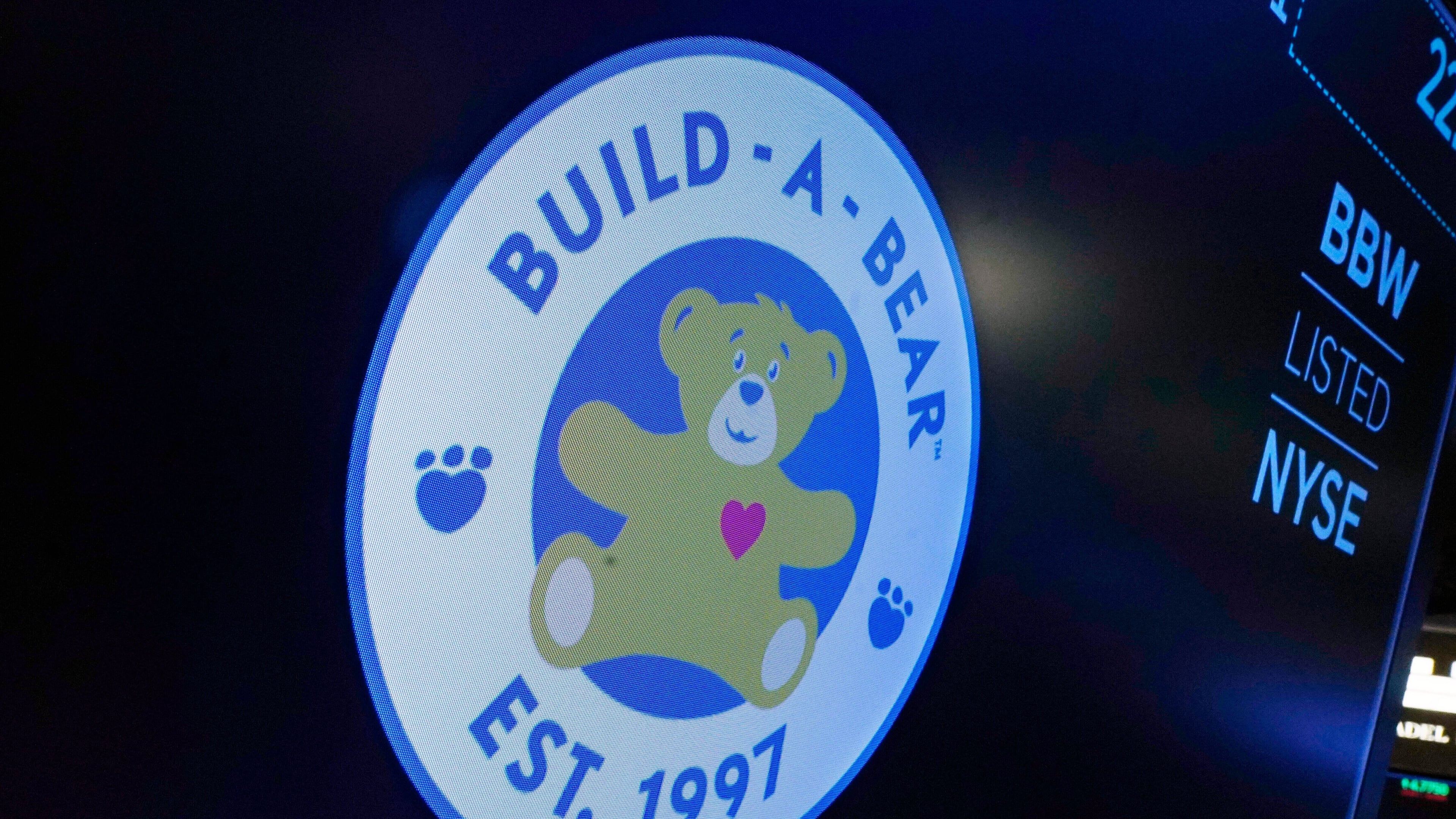FILE - The logo for Build-A-Bear Workshop appears above a trading post on the floor of the New York Stock Exchange, Dec. 1, 2021. (AP Photo/Richard Drew, File)