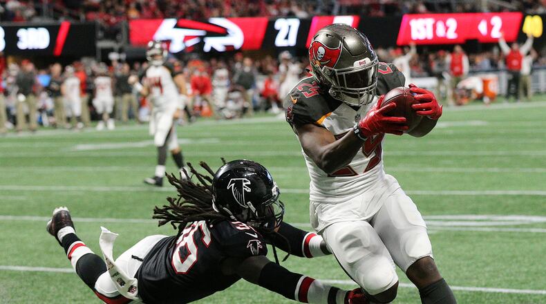 Buccaneers running back Peyton Barber gets past Falcons safety Kemal Ishmael for a touchdown on Sunday, Nov.26, 2017, in Atlanta.
