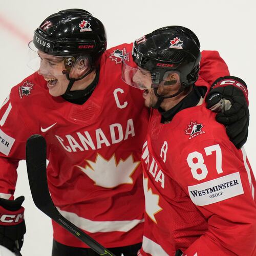 Canada's Sidney Crosby (87) celebrates with Macklin Celebrini (71) after scoring a goal during the third period of the 2026 IIHF Men's Ice Hockey World Championship quarterfinal match between Canada and United States, in Fribourg, Switzerland, Thursday, May 28, 2026. (AP Photo/Darko Bandic)
