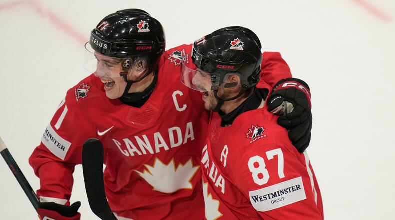 Canada's Sidney Crosby (87) celebrates with Macklin Celebrini (71) after scoring a goal during the third period of the 2026 IIHF Men's Ice Hockey World Championship quarterfinal match between Canada and United States, in Fribourg, Switzerland, Thursday, May 28, 2026. (AP Photo/Darko Bandic)