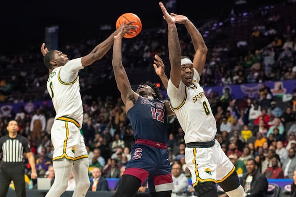 Norfolk State forward Tyrel Bladen, left, blocks a shot by South Carolina State guard Mitchell Taylor (12) during the second half of an NCAA college basketball game in the championship of the Mid-Eastern Athletic Conference Tournament, Saturday, March 15, 2025, in Norfolk, Va. (AP Photo/Mike Caudill)
