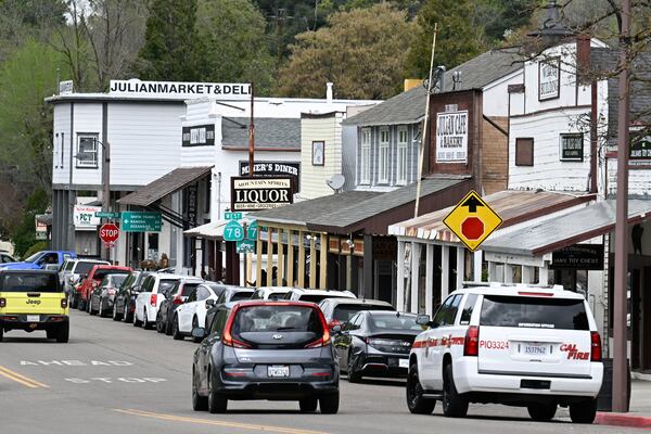 Cars drive on the main street in Julian, Calif. Monday, April 14, 2025, after an earthquake shook Southern California, sending boulders tumbling onto rural roadways outside San Diego and rattling items off shelves and walls. (AP Photo/Denis Poroy)
