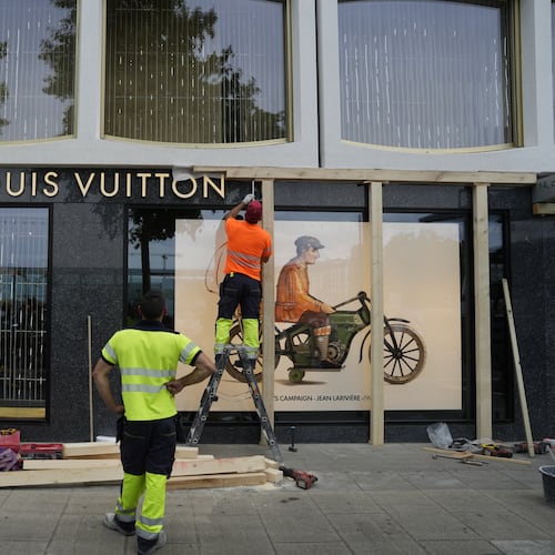 Construction workers board up a shop window, ahead of expected protests for the G7 summit, in Geneva, Switzerland, Monday, June 8, 2026. (AP Photo/Baz Ratner)