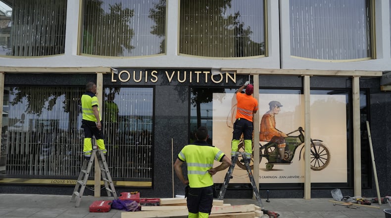 Construction workers board up a shop window, ahead of expected protests for the G7 summit, in Geneva, Switzerland, Monday, June 8, 2026. (AP Photo/Baz Ratner)