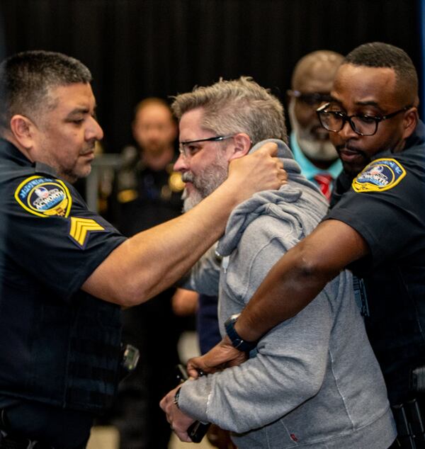 An attendee is removed by police at Marjorie Taylor Greene's town hall in Acworth on Tuesday, April 15, 2025. (Jenni Girtman for The Atlanta Journal-Constitution)