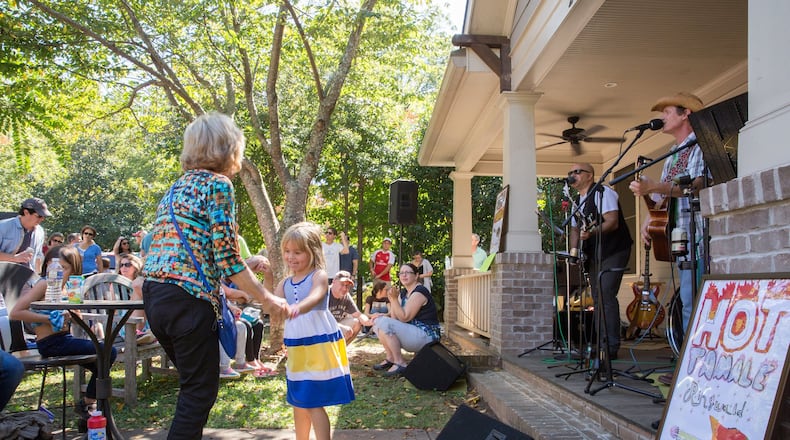 Hot Tamale Ringwald gets Chandler Campos of Sandy Springs, and her grandmother Cecy Compos of Alpharetta, on their feet and dancing at Porchfest in Oakhurst. (Photo by JENNI GIRTMAN)