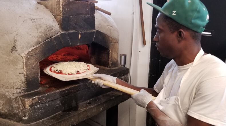 Chef John Hall bakes pizza in a wood-fired oven at Post Office Pies in Birmingham, Ala. Contributed by Wesley K.H. Teo
