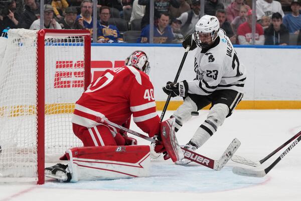 Boston University goaltender Mikhail Yegorov, left, deflects a shot from Western Michigan's Liam Valente (23) during the first period in the championship game of the NCAA Frozen Four men's college hockey tournament, Saturday, April 12, 2025, in St. Louis (AP Photo/Jeff Roberson)