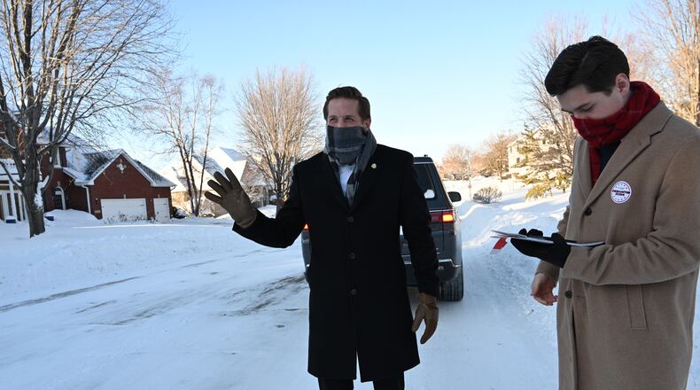U.S. Rep. Rich McCormick assisted by his aid Jonathan Casas waves to a car as he is knocking on doors to encourage to vote for Republican presidential candidate Florida Gov. Ron DeSantis in a neighborhood, Sunday, January 14, 2024, in West Des Moines, Iowa. (Hyosub Shin / Hyosub.Shin@ajc.com)