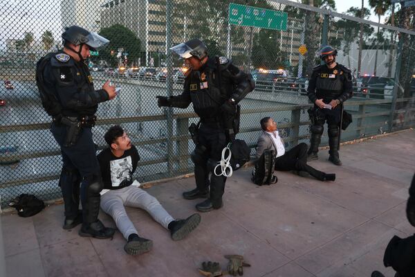 California Highway Patrol officers arrest two men after a dispersal order during a protest Saturday, June 14, 2025, in Los Angeles. (AP Photo/Ethan Swope)