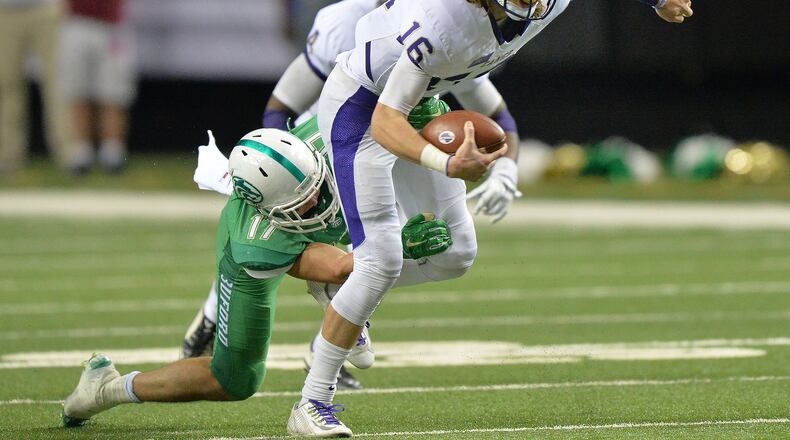 Cartersville Trevor Lawrence (16) gets tackled by Buford Jake Simpson (17) during Cartersville's 10-0 win over Buford in the GHSA Class AAAA State Championship at the Georgia Dome on Saturday December 12, 2015. HYOSUB SHIN / HSHIN@AJC.COM
