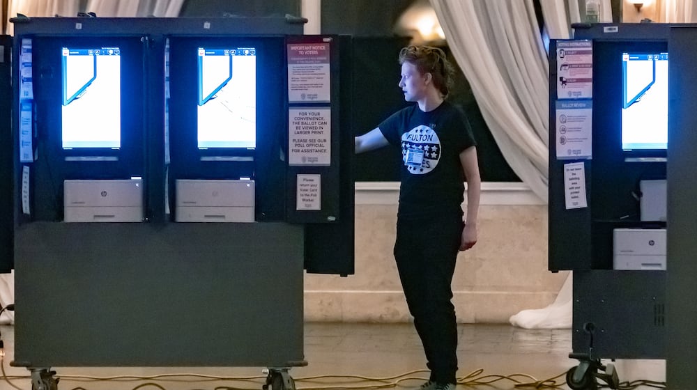 Poll worker Gamble Everett prepares machines in the voting area before the polls opened on Tuesday, March 12, 2024, at the polling place at the Park Tavern, 500 10th Street NE in Atlanta. (John Spink/AJC)