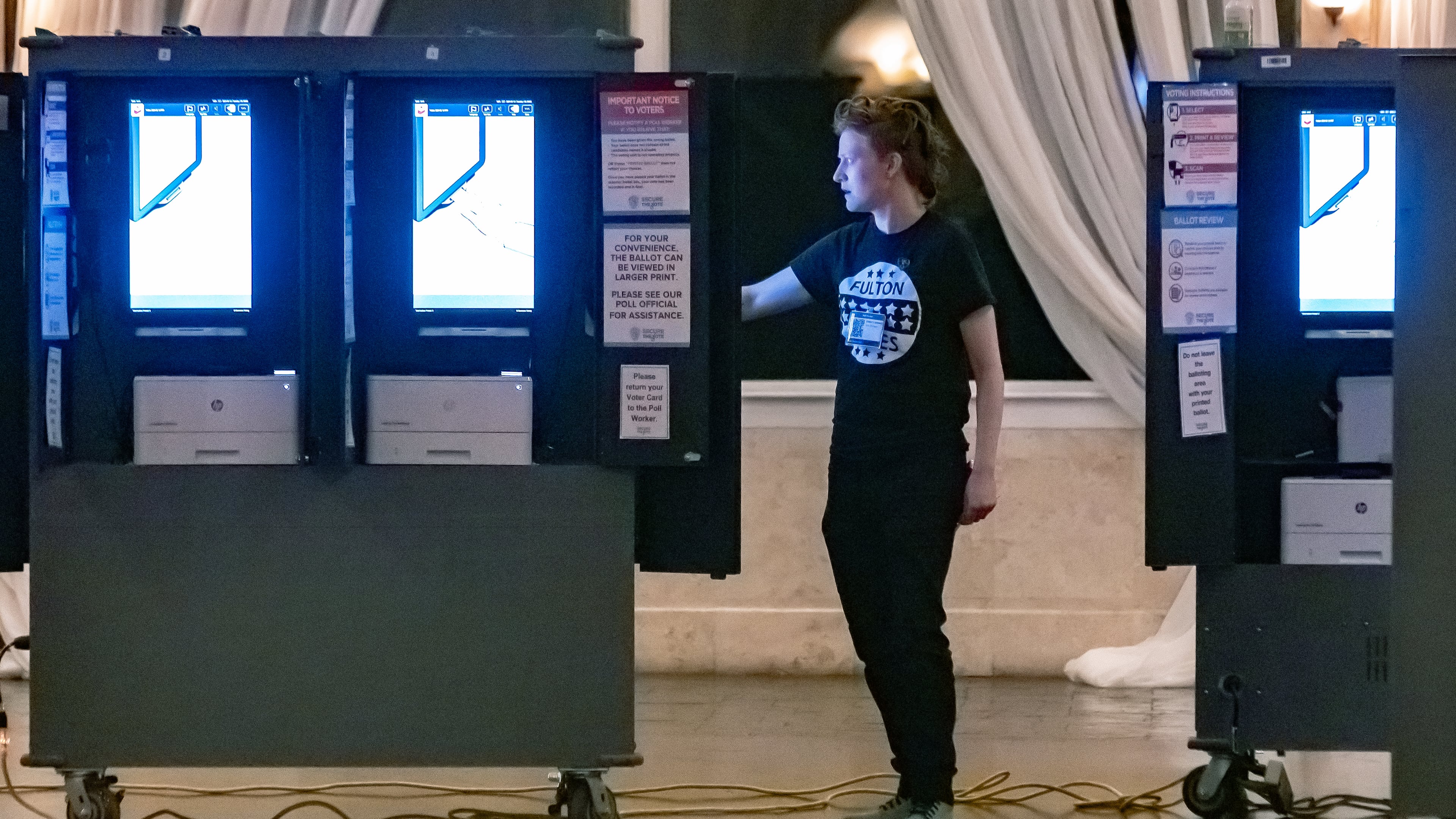 Poll worker Gamble Everett prepares machines in the voting area before the polls opened on Tuesday, March 12, 2024, at the polling place at the Park Tavern, 500 10th Street NE in Atlanta. (John Spink/AJC)