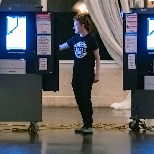 Poll worker Gamble Everett prepares machines in the voting area before the polls opened on Tuesday, March 12, 2024, at the polling place at the Park Tavern, 500 10th Street NE in Atlanta. (John Spink/AJC)