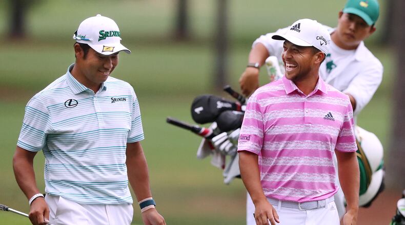 Hideki Matsuyama and Xander Schauffele share a laugh after they both made eagle putts on the 15th green during the third round of the Masters on Saturday, April 10, 2021, in Augusta. “Curtis Compton / Curtis.Compton@ajc.com”