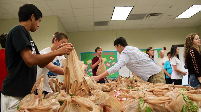 Student volunteers gather at Lambert High School to pack food for Blessings in a Backpack, a local program that aims to alleviate hunger for at-risk children in Forsyth County.