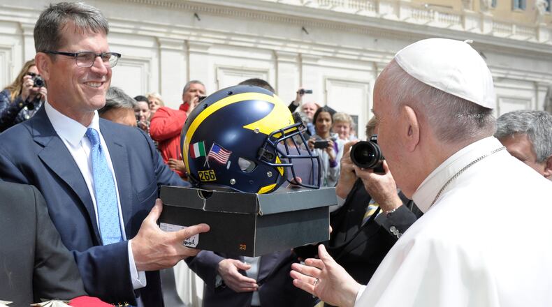 Pope Francis is presented with a football helmet by Michigan football team coach Jim Harbaugh during the weekly general audience at the Vatican, Wednesday, April 26, 2017.