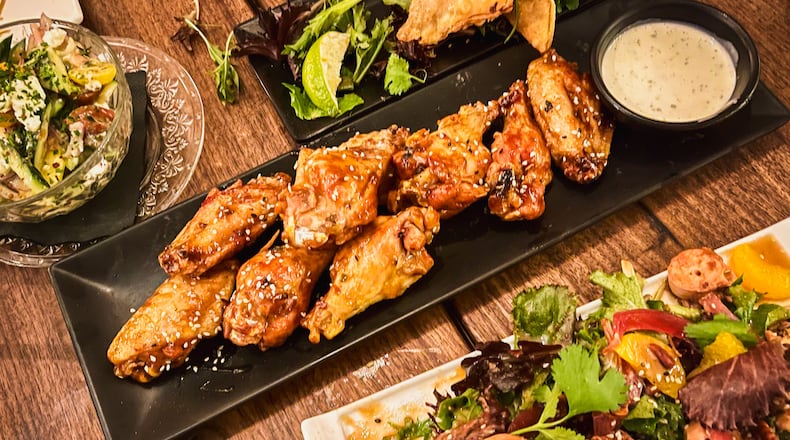 Wings, empanadas and grilled octopus with mixed greens are among the options at Marietta Proper. Henri Hollis/henri.hollis@ajc.com