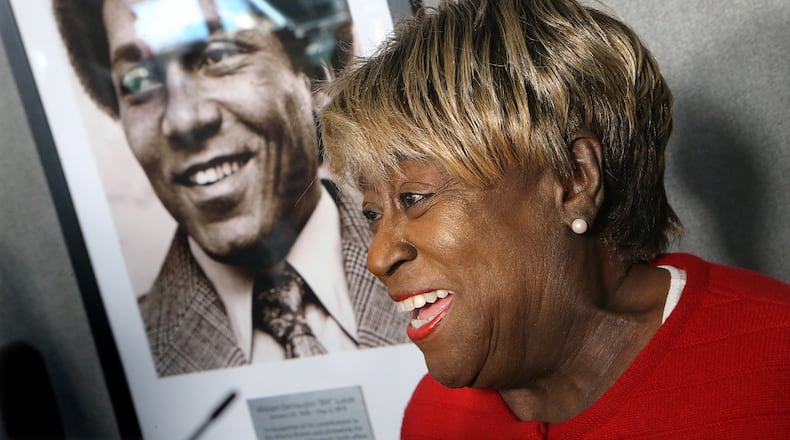 Rubye Lucas, widow of Bill Lucas, speaks next to his portrait during a ceremony naming the Braves' baseball operations conference room after Lucas, baseball's first Black general manager, in 2017. The dedication coincided with the 40th anniversary of Lucas' first season as Atlanta's vice president of player personnel. (Curtis Compton/AJC 2017)