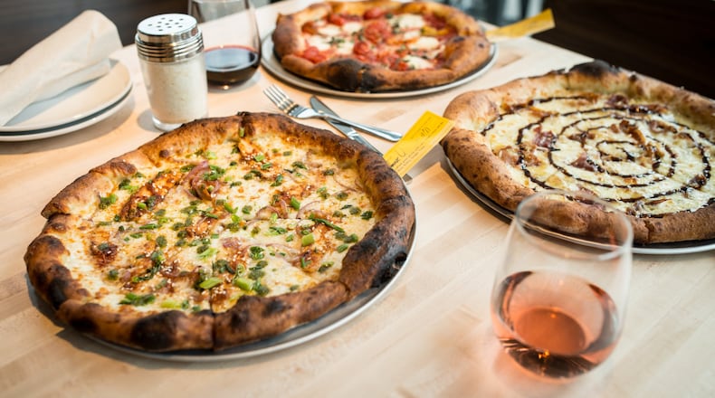 Rize Asian BBQ Chicken signature pizza with green chili sauce, Classic Margherita pizza with fire roasted tomatoes, and Waverly signature pizza with prosciutto, cheeses, and fig jam. Photo Credit- Mia Yakel.