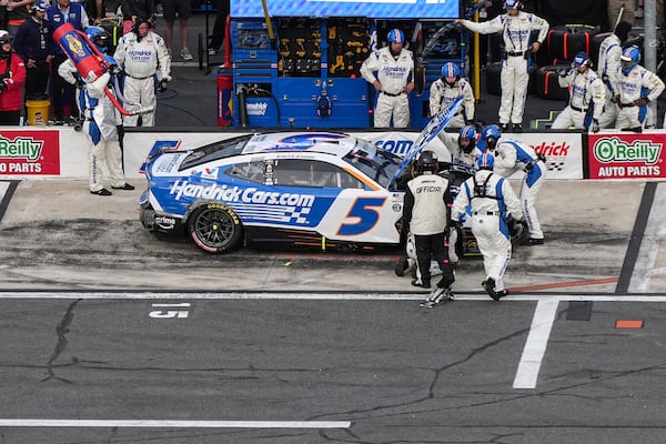 The pit crew for Kyle Larson looks under the hood of the car during a NASCAR Cup Series auto race at Charlotte Motor Speedway, Sunday, May 25, 2025, in Concord, N.C. (AP Photo/Matt Kelley)
