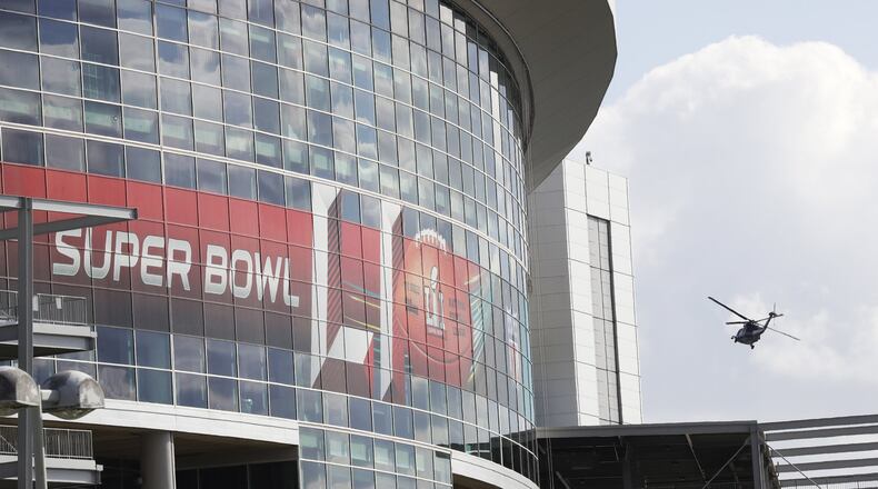 A helicopter flies over Houston’s NRG Stadium. (AP Photo/Morry Gash)