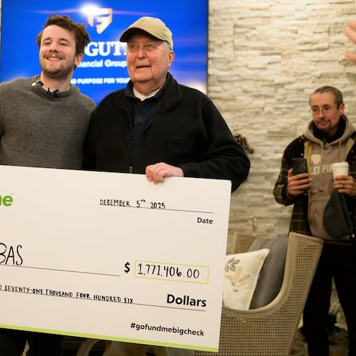 Influencer Samuel Weidenhofer, left, poses for a photo with Ed Bambas, right, the 88-year-old Brighton resident who is the recipient of over $1.7 million after a viral Gofundme campaign was started by Weidenhofer, after the amount is revealed to Bambas, Friday, Dec. 5, 2025, in Brighton, Mich. (Katy Kildee/Detroit News via AP)