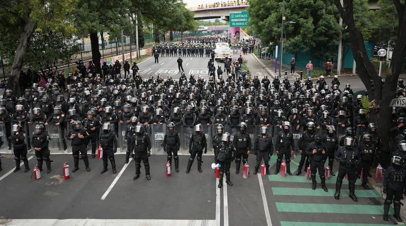 Police block an avenue to prevent protesting teachers from marching to the stadium that will host the opening match of the FIFA World Cup in Mexico City, Tuesday, June 9, 2026. (AP Photo/Eduardo Verdugo)