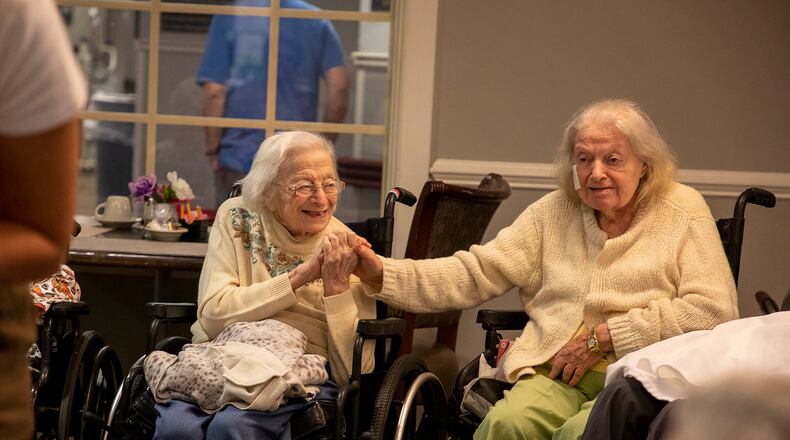 Ann Gintis, of West Philadelphia, left, holds her friend’s hand, Audrey Garner, of North East Philadelphia, right, during an exercise class with other nursing home residents on Thursday, Aug. 15, 2019. (Tyger Williams/The Philadelphia Inquirer/TNS)