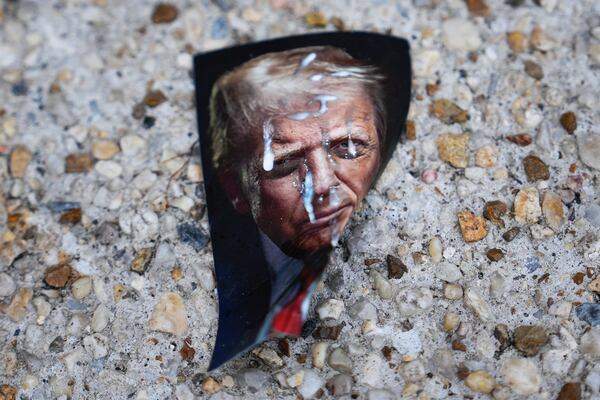 A picture of President Donald Trump lays on the ground near the White House ahead of an upcoming military parade commemorating the U.S. Army's 250th anniversary and coinciding with Trump's 79th birthday, Saturday, June 14, 2025, in Washington (AP Photo/Julia Demaree Nikhinson)